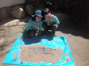 Y. and his little sister S. writing their names