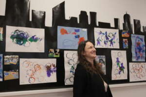 Jamie Cowan in front of student art at celebration