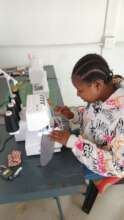 A community member sewing reusable sanitary pads