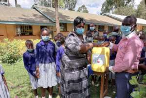 Giving hand wash soap to Shivakali headteacher