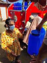 Firefighters bring water to the distribution event