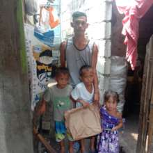 Father and children receive food and hygiene items