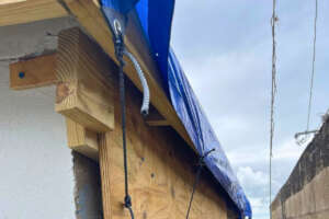 Temporary tarp covering exposed roofline