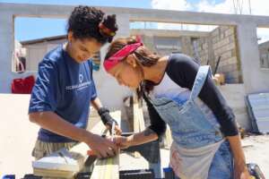 Franceliz shares carpentry tips with a trainee.