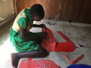 A teenage girl learning how to cut fabrics
