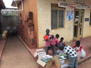 Children rest their water jerrycans aside to read
