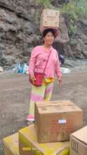 Tribal woman carries box of books on her head