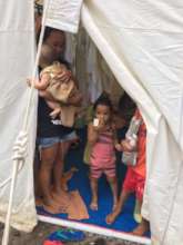Families in temporary evacuation site tent