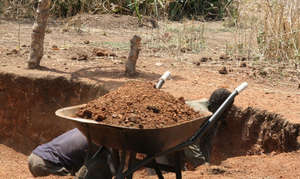 Omilling, a wheelbarrow full red soil marram
