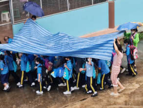 Youngest girls travel under the "Tarp Umbrella"