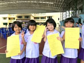 Girls proudly hold their Health Screening charts