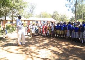 Denge talking to primary school children.