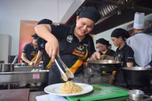 A KOTO trainee learning to cook pasta