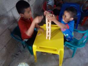 Two students building a tower with wood blocks
