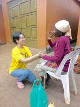 A volunteer, Sayaka, assisting an elderly woman