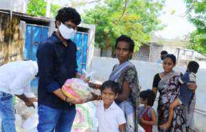 Project leader distributing the releif in a slum