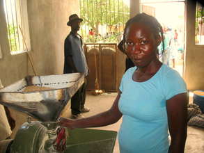 Woman operating a local grain mill in Haiti