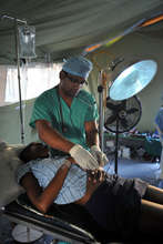A doctor prepares the patient for anaesthesia