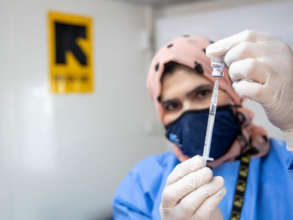 An IRC nurse prepares a COVID-19 vaccine dose