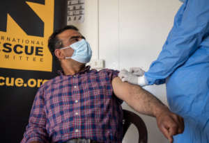 A Syrian refugee proudly receives his vaccine