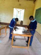 Students repairing one of their woodwork tools