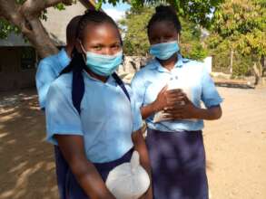 Girls receiving rice to take home during covid
