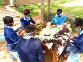 Students learning how to make mats outside