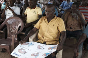 Community elder engaging with WASH poster
