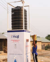 Girl draws water from the Maji Kiosk