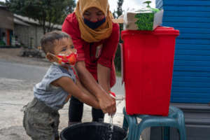 Mother washes her child's hands in Indonesia