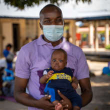 PIH doctor holds baby Naphtal in Sierra Leone