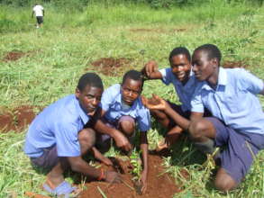 some beneficiaries at school doing planting a tree