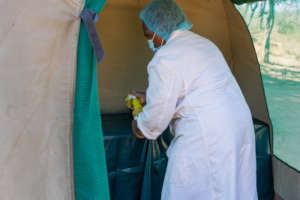 Sanitizing clinic tent before service provision.