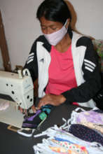 A woman sews fabric masks for her community