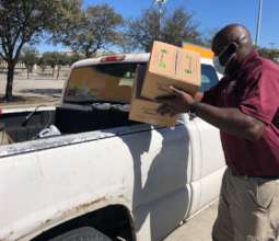 Volunteer loads truck at HISD distribution.