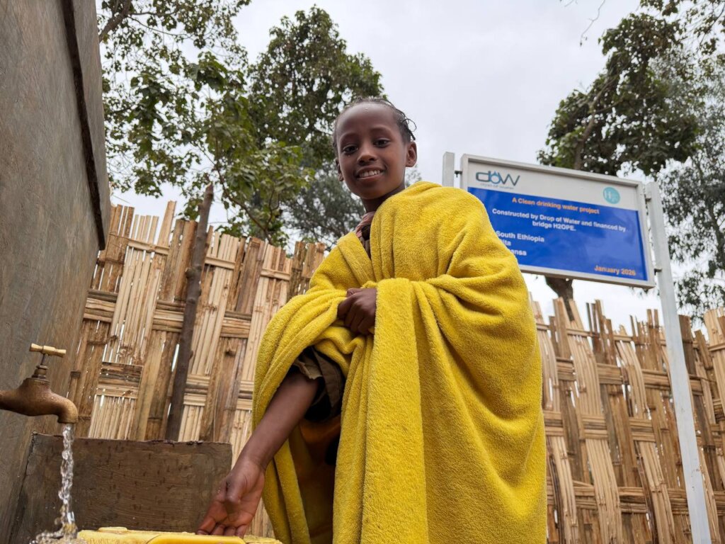 rural girl fetching water from a well built by DOW