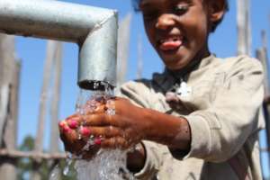 Happy girl washing hand from Drop of water well