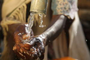 A community member washing her hands