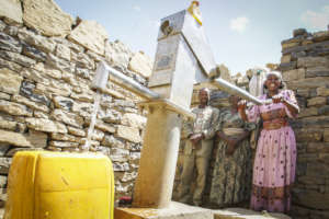 Woman pumping water from Drop of Water well