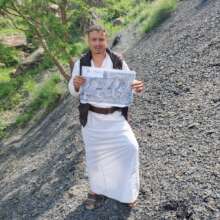 A VOLUNTEER GAURD HOLDING A POSTER