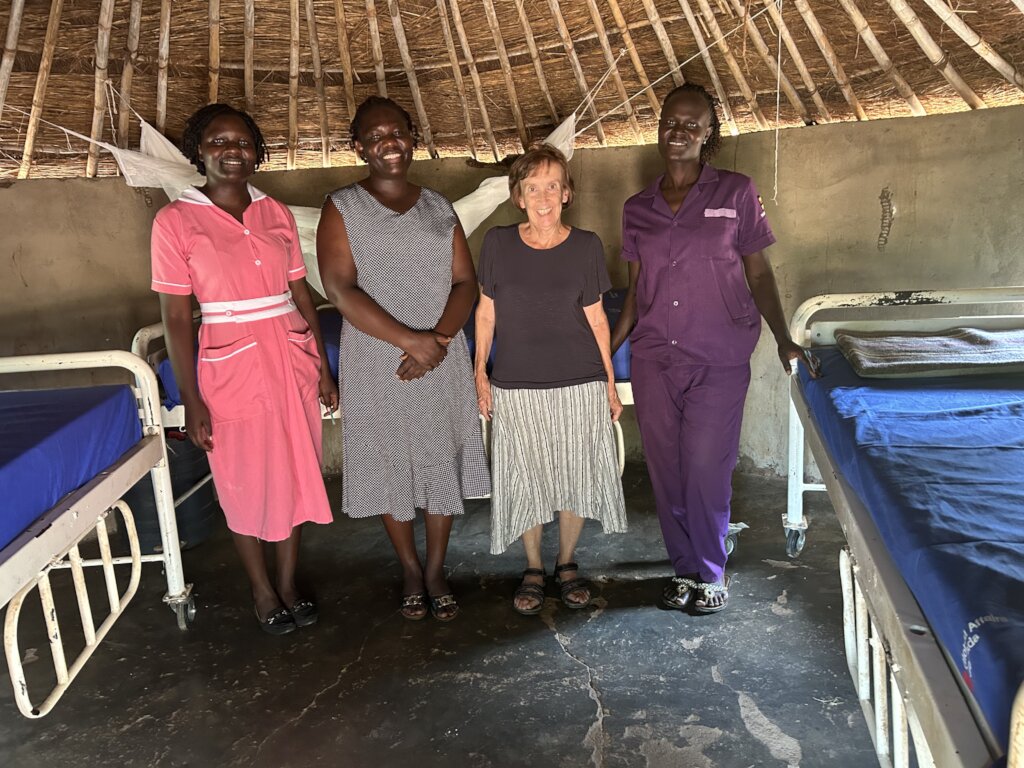 Carol with two clinic nurses inside maternity hut