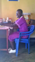 Nursing Assistant Beatrice at her clinic desk
