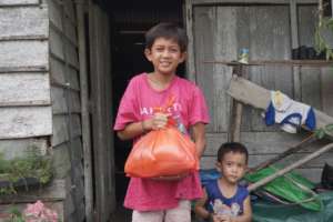 Two siblings receiving YUM's food package