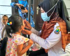 A nurse giving a child deworming treatment