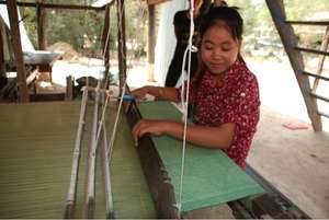 Vannah oversees a worker at a weaving loom