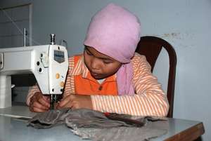 A young girl learning sewing skills