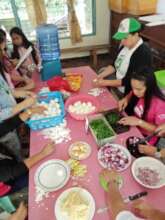 Mothers and volunteers cooking lunch at school