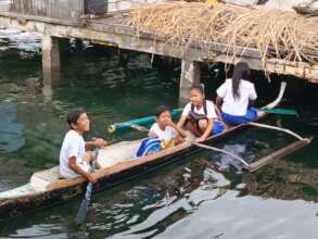 Children travel to school by small canoes