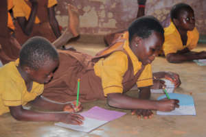 School children sitting on the floor.