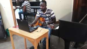 Teacher George delivering an online guitar lesson